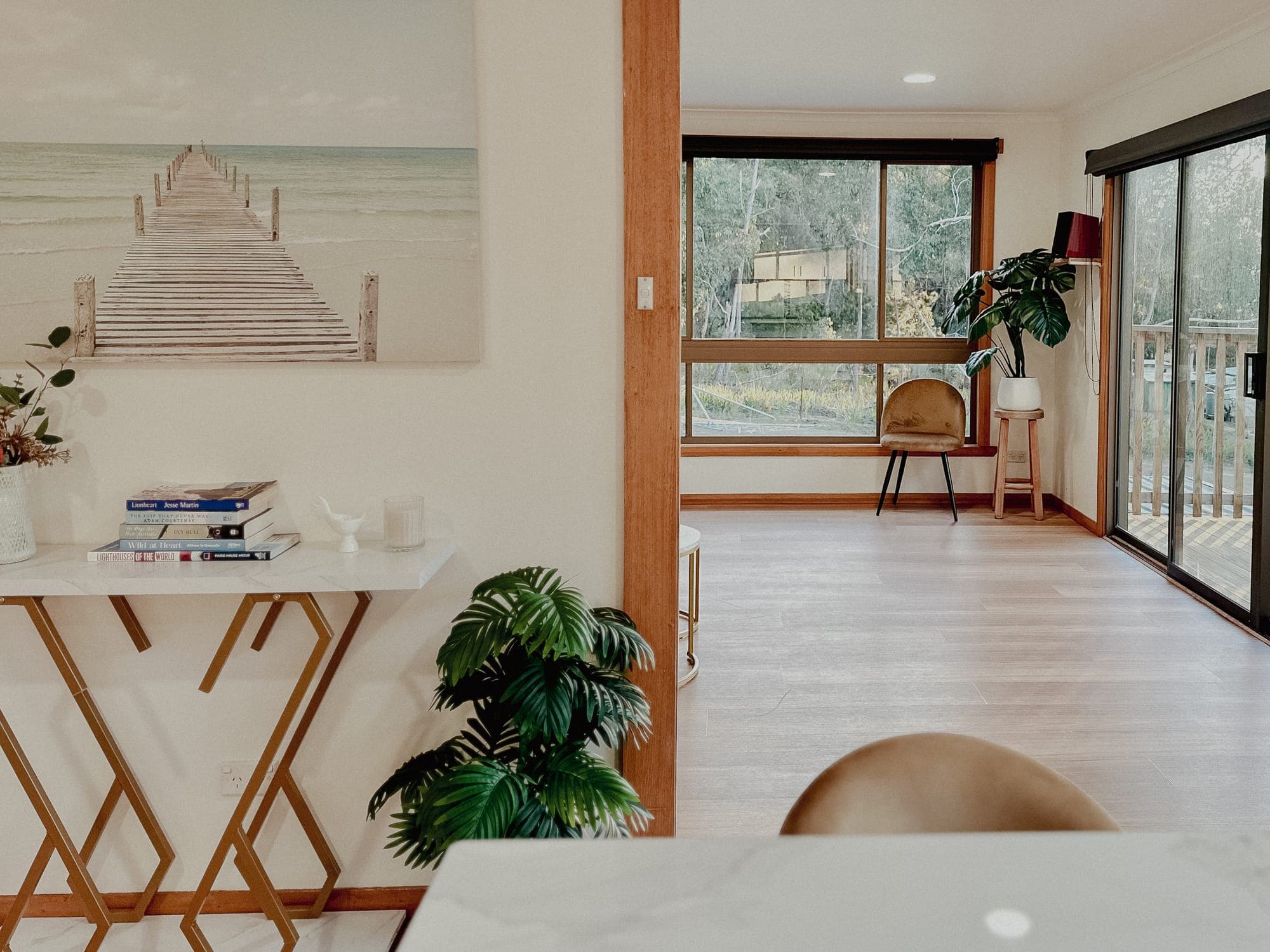 LunaStay living room — entry console flowing into the sun-lit sunroom