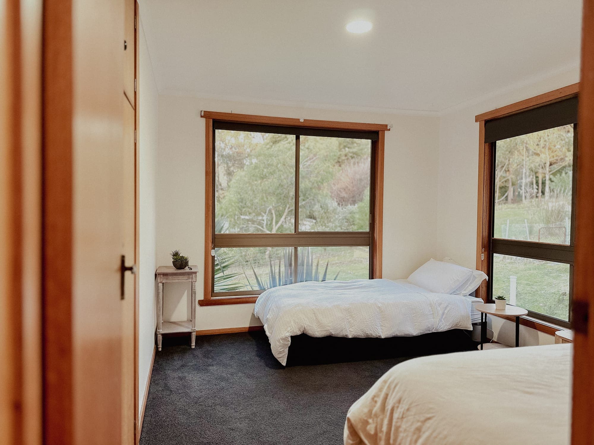 LunaStay — third bedroom with two single beds and corner windows